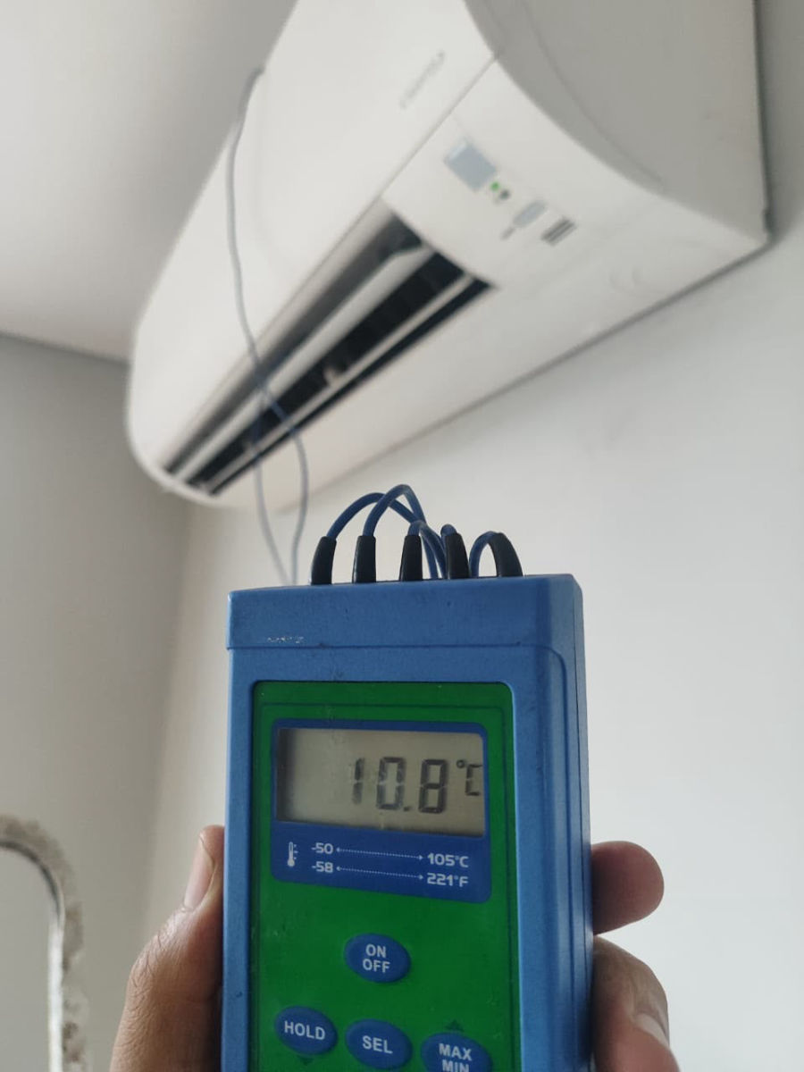 Termômetro digital marcando 10,8 graus na saída de ar da evaporadora